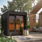 Sauna Arlen Premium mustalla ulkoviimeistelyllä ja puukiukaalla terassilla